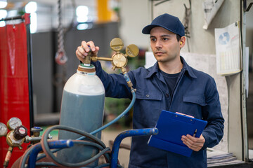 Inspector checking a gas tank in a factory