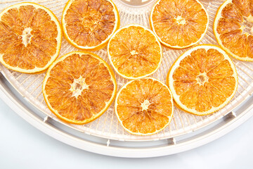 dried citrus fruit slices on a plastic drying tray