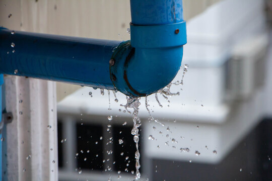 Closeup view of leaked and splash water from the plastic pipe during the rainy day