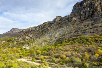 a panoramic view of the beautiful mountains with unusual ledges and rocks against the background of the sky and the valley filmed from a drone