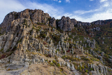 a panoramic view of the beautiful mountains with unusual ledges and rocks against the background of the sky and the valley filmed from a drone