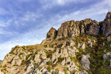 Fototapeta premium a panoramic view of the beautiful mountains with unusual ledges and rocks against the background of the sky and the valley filmed from a drone