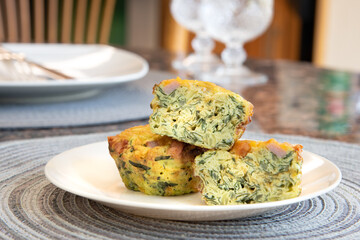 Breakfast Egg Muffins loaded with fluffy eggs, potatoe, spinach, melted cheese and crisp bites of Canadian bacon.