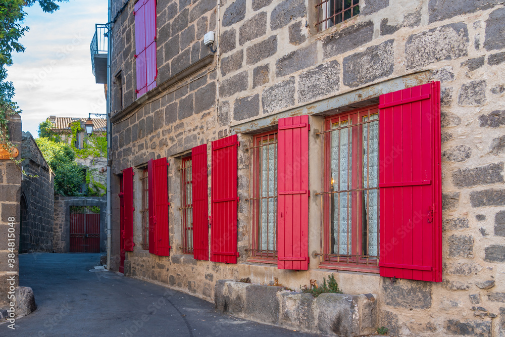 Poster small street at agde centre with old buildings with red windows