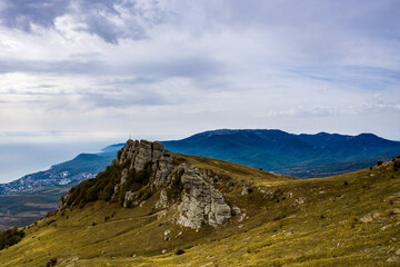 Fototapeta premium a panoramic view of the beautiful mountains with unusual ledges and rocks against the background of the sky and the valley filmed from a drone
