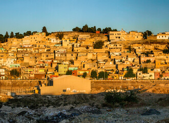 Obraz premium City town buildings with old facade and tumbledown neighborhood in middle east with yellow sunset
