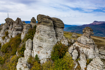 a panoramic view of the beautiful mountains with unusual ledges and rocks against the background of the sky and the valley filmed from a drone