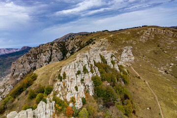 a panoramic view of the beautiful mountains with unusual ledges and rocks against the background of the sky and the valley filmed from a drone
