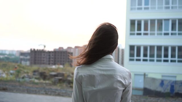 Rear back view of successful businesswoman. The wind blows the hair, slow motion