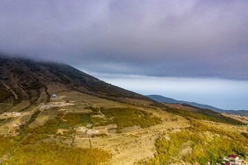 beautiful mountains with unusual ledges and tales against the background of the sky and a valley with fog filmed from a drone