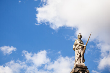 Antique statue of a Roman goddess on the background of the sky with clouds