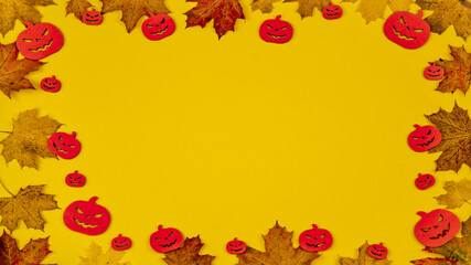 Halloween / autumnal autumn background template design - Frame made of colorful fallen leaves and wooden pumpkins isolated on yellow paper texture, with space for text