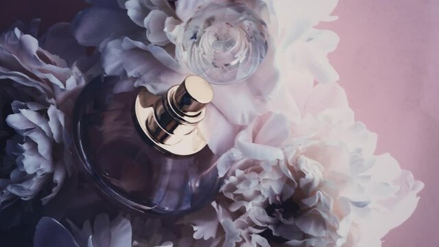 Purple perfume bottle with peony flowers, chic fragrance scent as luxury cosmetic, fashion and beauty product background, stock footage