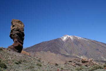 Fototapeta na wymiar Senkrecht aufragender Fels mit Berg Teide und blauem Himmel im Hintergrund