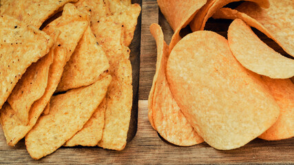 Chips, snacks and crackers on a wooden board. Fast food.