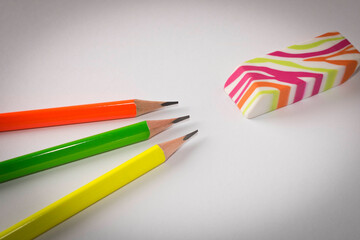 Fototapeta premium Colorful eraser and simple pencils on a light background. Close up. Selective focus.