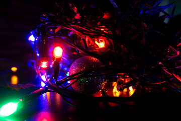 Christmas garland and ball in the dark. The spirit of the winter holidays.