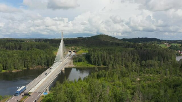 Aerial view away from traffic on the Smaalenene Bridge, at the Glomma river, sunny, summer day, in Spydeberg, Agder, Norway - tracking, pan, drone shot