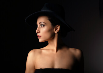 Beautiful makeup woman with elegant healthy neck, nude back and shoulder on black background in fashion hat with empty copy space. Closeup profile view portrait. Art.