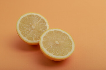 un limón cortado a la mitad sobre un fondo naranja claro