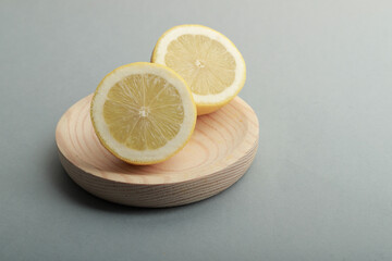 un limón a la mitad sobre un plato de madera claro fotografiado en estudio