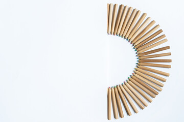 Wooden pencil collection for painting isolated on white background. Back to school concept. Horizontal view of sorted pencils put together on a semi circle form by different color and shape.