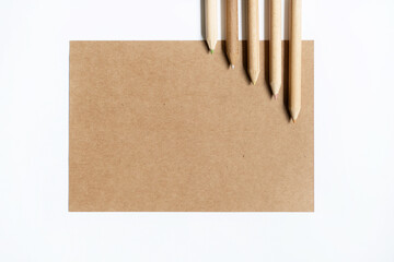 Blank mockup of creativity inspiration. Sort of pencils and recycled paper note isolated on white background. Horizontal view of set of empty piece of paper and different color pencils ready to draw. 
