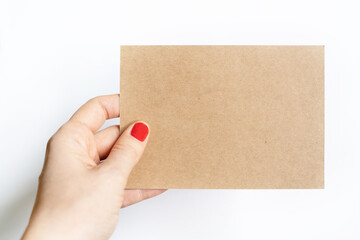 Obraz premium Horizontal view of unrecognizable woman holding a blank piece of recycled paper. Unrecognizable woman hand holding a recycled piece of paper note isolated on white background.