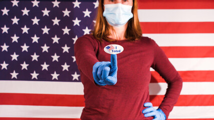 Woman with medical gloves and mask showing I Voted sticker for american presidential elections.