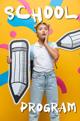 Worried schoolchild with backpack and paper pencil looking at camera near school program lettering...