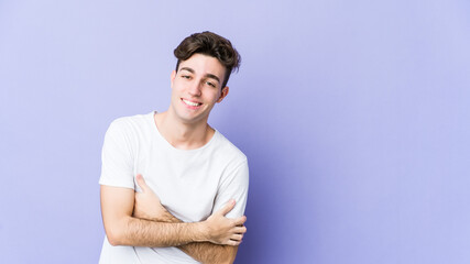 Young caucasian man isolated on purple background laughing and having fun.