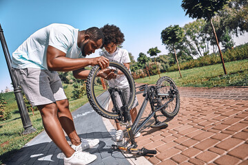 Father and son spending time together and fixing a bicycle