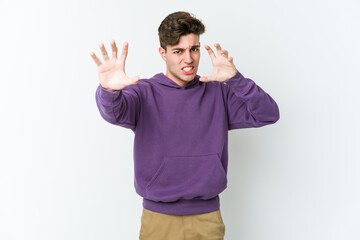Naklejka premium Young caucasian man isolated on white background upset screaming with tense hands.