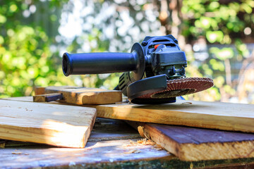 A manual grinder lies on a wooden table.