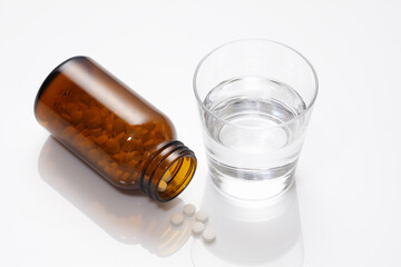Fototapeta premium 錠剤の入った薬ビンとコップの水