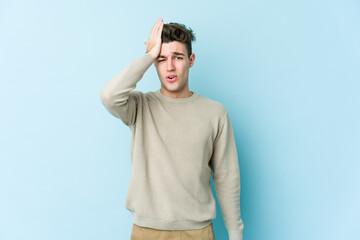 Young caucasian man isolated on blue background forgetting something, slapping forehead with palm and closing eyes.