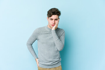 Young caucasian man isolated on blue background who feels sad and pensive, looking at copy space.