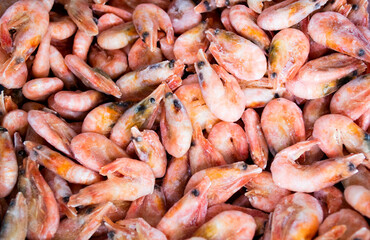 Close-up of a pile of frozen pink shrimps. Natural pink seafood background
