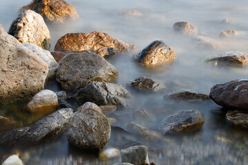 Rocky stretch of coast of the Mediterranean Sea on the Greek Aegean island of Samos with a calm water surface.