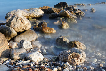 Rocky stretch of coast of the Mediterranean Sea on the Greek Aegean island of Samos with a calm water surface.