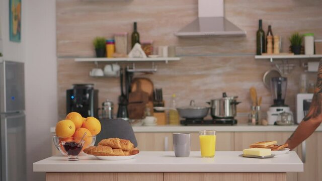 Lady in black lingerie preparing healty breakfast in the morning in modern kitchen. Young sexy seductive blode woman with tattoos drinking healthy, natural homemade orange juice, refreshing sunday.