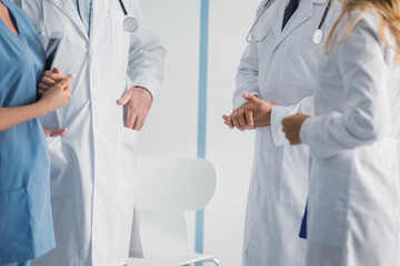 Cropped view of doctors and nurse with digital tablet standing in clinic