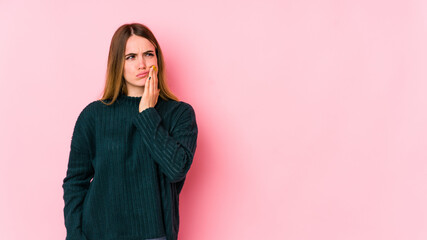 Young caucasian woman isolated on pink background having a strong teeth pain, molar ache.