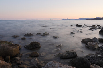 Rocky stretch of coast of the Mediterranean Sea on the Greek Aegean island of Samos with a calm water surface.