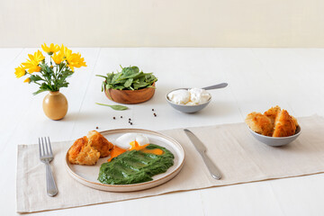 Homemade fresh creamy spinach and poached egg with roasted bread. Delicious healthy brunch or lunch.