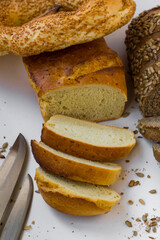 Sliced potato bread on white background with sesame bread and knife,vertical image