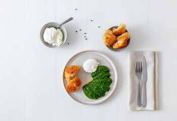 Homemade fresh creamy spinach and poached egg with roasted bread. Delicious healthy brunch or lunch. top down view.