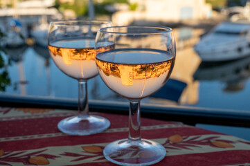 Drinking of local rose wine in summer with sail boats haven of Port Grimaud on background, Provence, France