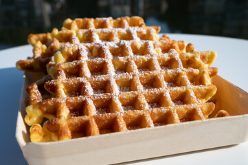 Sweet fresh baked Belgian waffles served outdoor with view on Maas river in Dinant, Wallonia, Belgium.