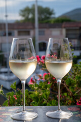 Tasting of local white wine in summer with sail boats haven of Port Grimaud on background, Provence, France